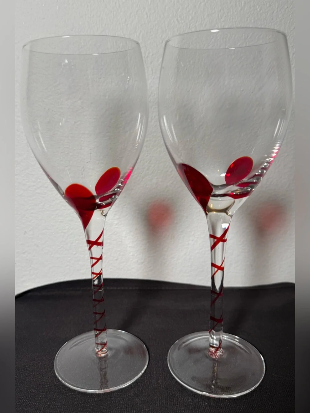 2 Pier 1, red ribbon swirl stem wine glasses, w/ a red swirl design on the stem.